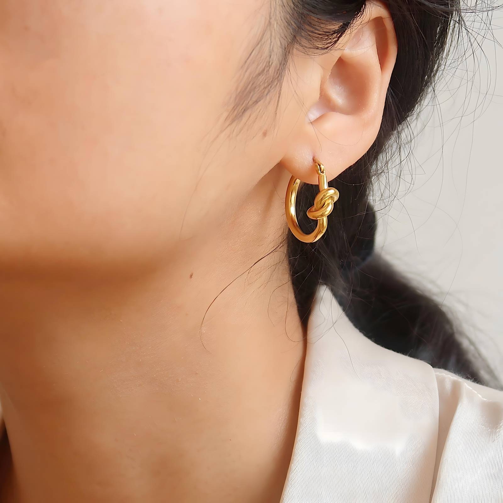 18K gold plated knot earrings worn close-up UAE