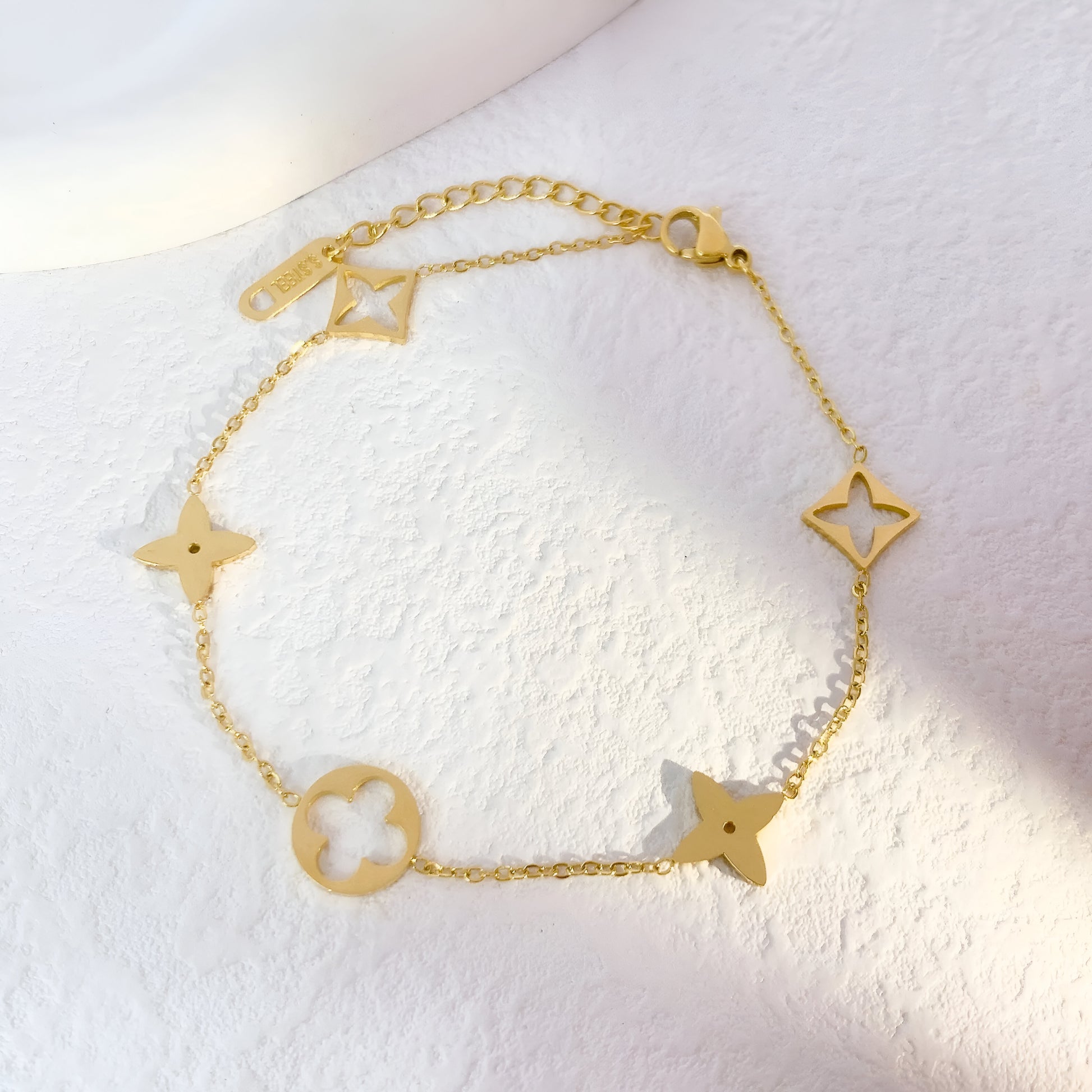 Gold bracelet with star-shaped charms on a white background